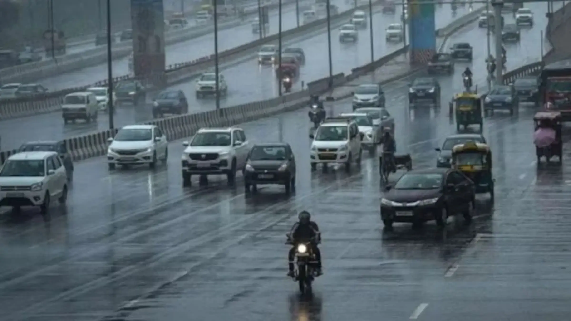 Delhi road with vehicles on a rainy day