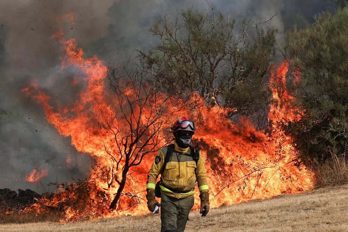 A firefighter changes position during operations to battle a wildfire in Spain
